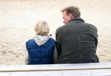 Back view of father and son talking on playground