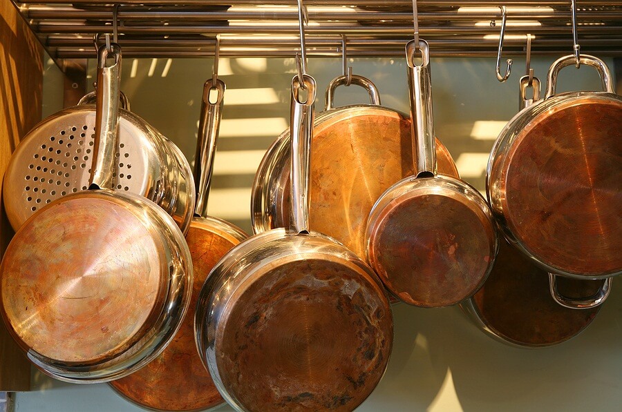 Copper pots and pans hung up on wall