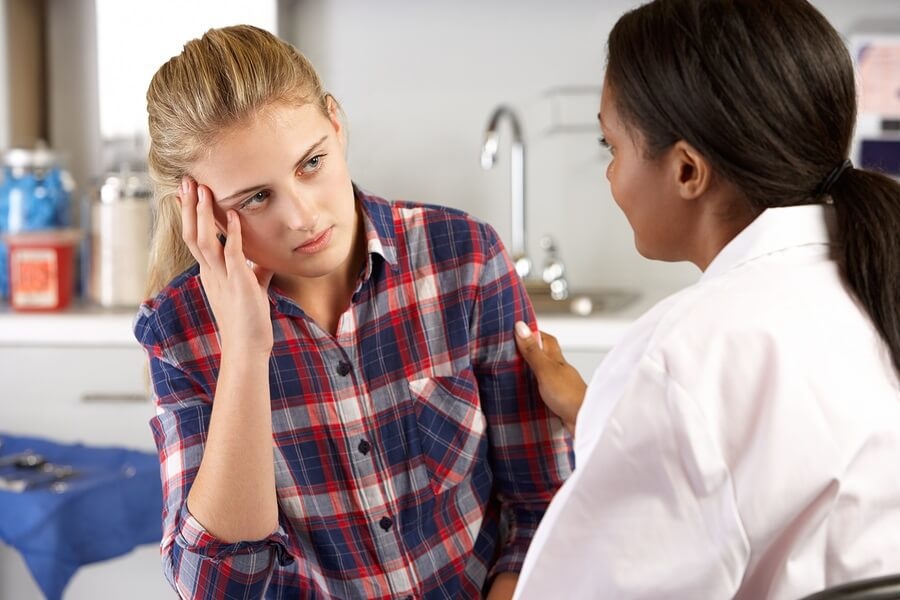 Depressed teen girl talking to doctor