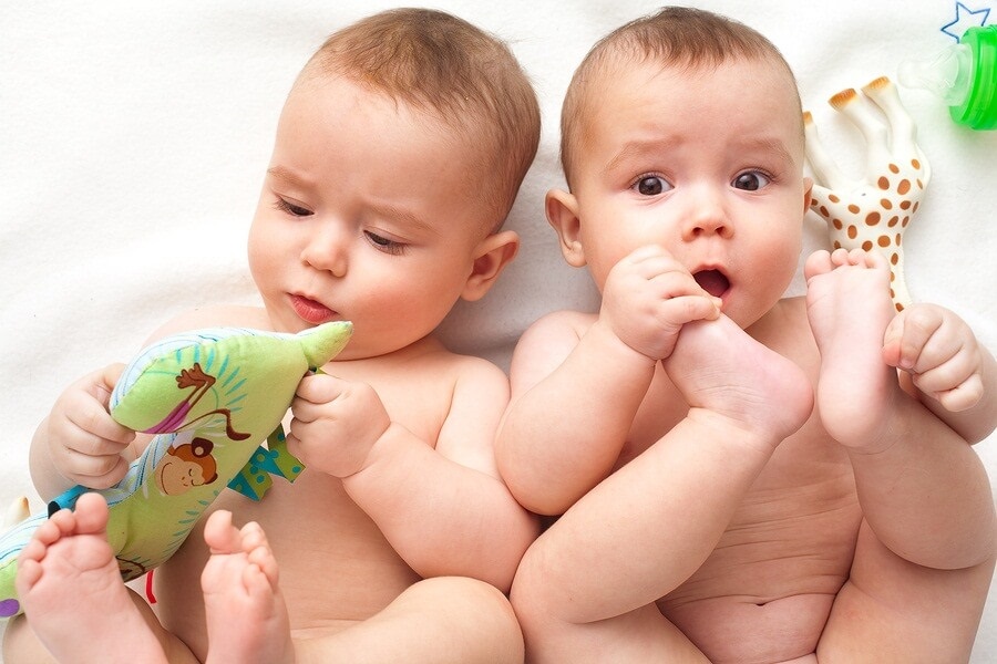 Twin boys in bath playing with toys