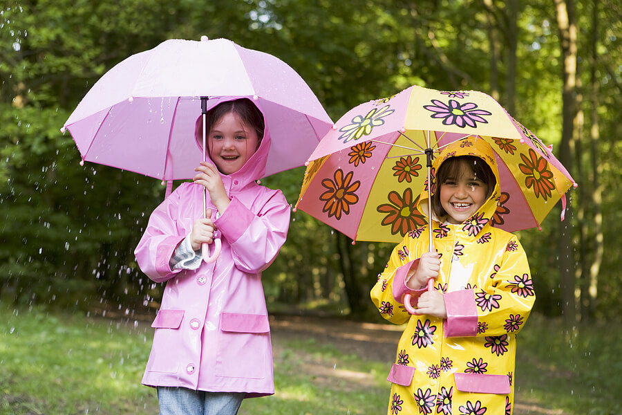 Summer camp essentials, two girls in raincoats with umbrellas