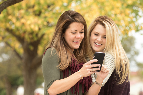 Mom and teenage daughter in college connecting over the phone