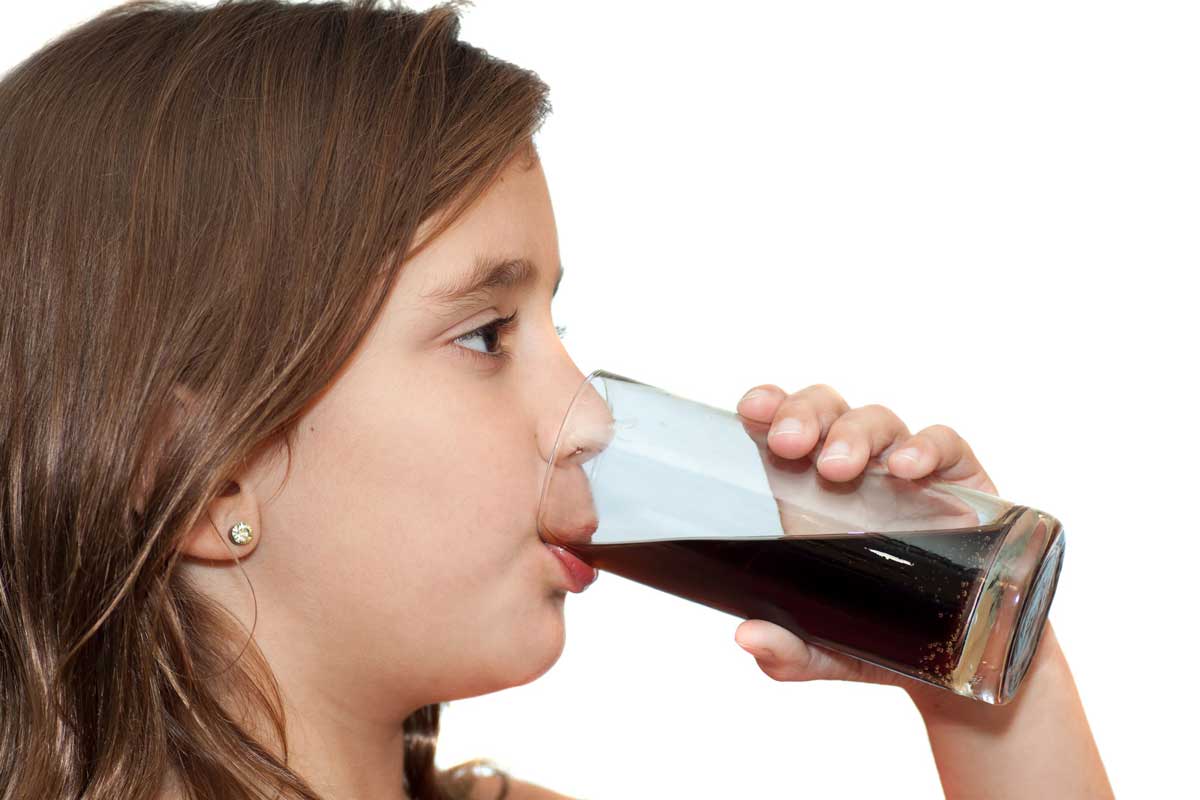 young girl drinking glass of soda
